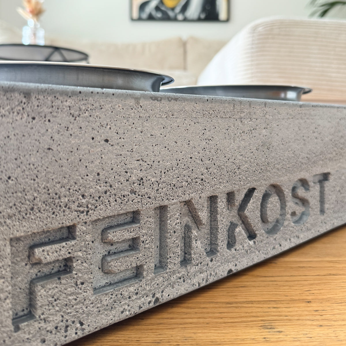 Eingegossener Hundename im grauen Beton, Nahaufnahme der Personalisierung mit sichtbarer Betonstruktur