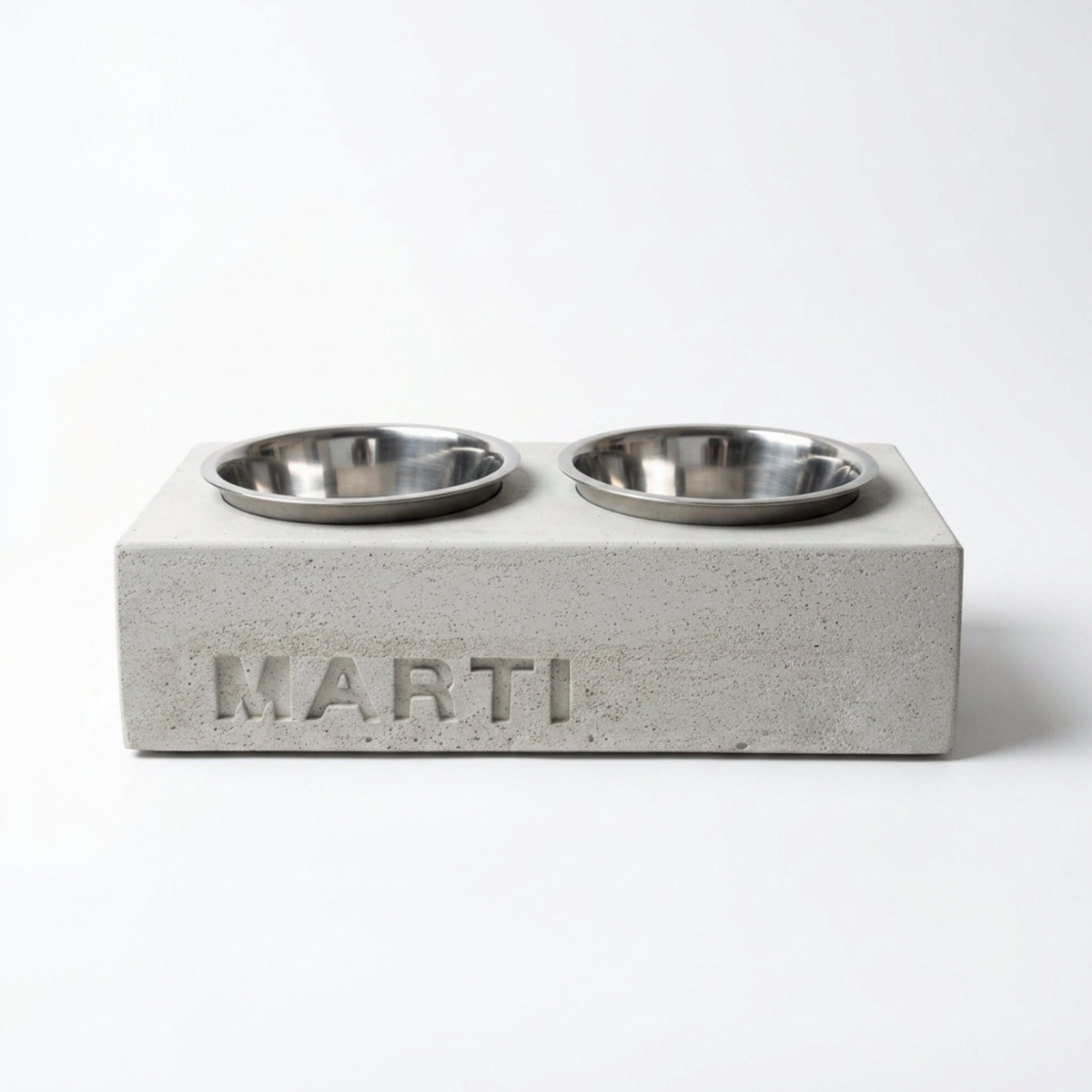 Napfhalter aus Beton mit personalisiertem Namen, frontal auf weißem Hintergrund, mit zwei Edelstahlnäpfen